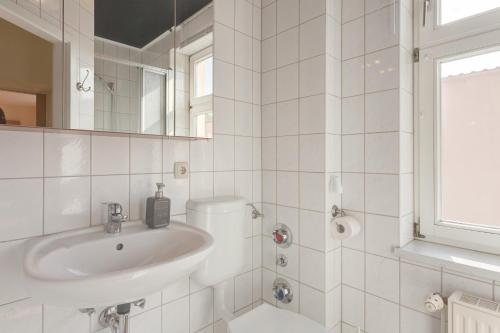 a white bathroom with a sink and a mirror at Altstadt Ferienwohnung in Neuruppin