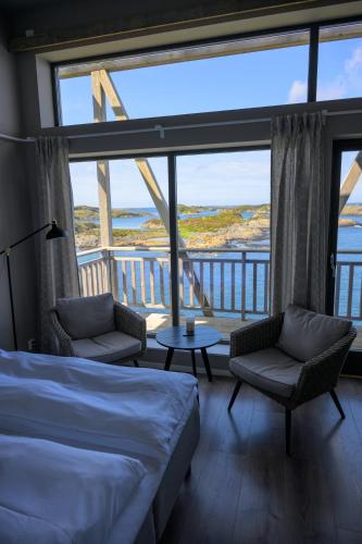 a bedroom with a bed and a view of the ocean at Værlandet Havhotell in Hamna