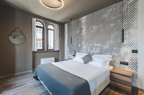 a bedroom with a large bed and a wall with patterns at 9 stanze - Boutique Rooms in Trieste