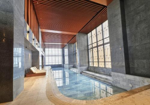 Una gran piscina en un edificio con ventanas. en Antara Genting Jaccuzi Mountain View 3BR -8pax FREE 2CP, en Genting Highlands