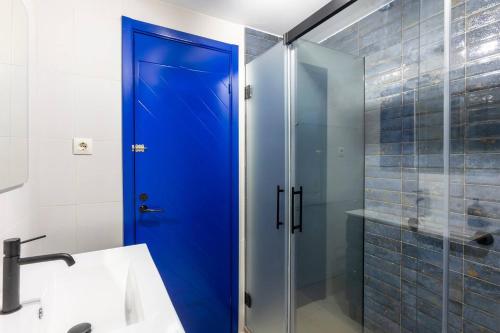 - Puerta azul en el baño con ducha en adosado con piscina junto a la playa, en Salobreña