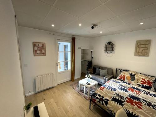 a living room with a bed and a couch at Studio Jacuzzi & Private Cinema - Paris south in Le Perreux-Sur-Marne