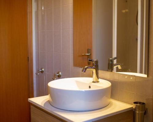 Un baño con un lavabo blanco y un espejo. en Meteora Palizzi, en Palizzi Marina