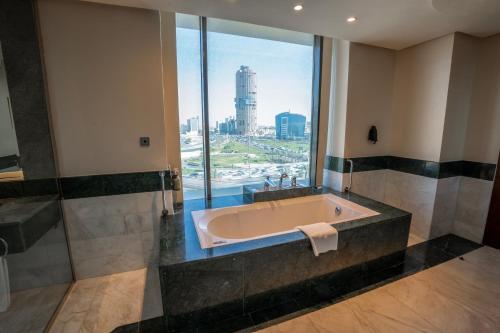a bath tub in a bathroom with a large window at Holiday Inn Olaya by IHG in Riyadh