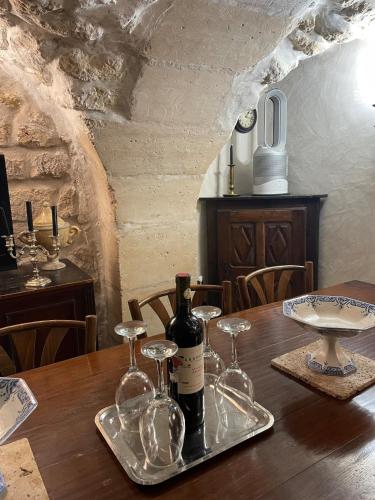 a table with a bottle of wine and glasses on it at Marais Romantique Paris centre 4 chambres in Paris