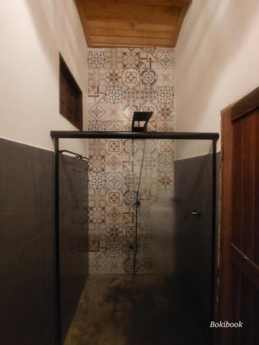 a walk in shower in a room with a tile wall at Xodó Tiny House in Marau