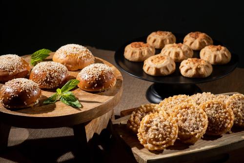 une table avec deux assiettes de beignets et autres pâtisseries dans l'établissement Villa Elite "by Checkin" Adults Only, à Chersónissos