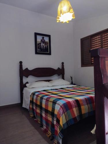 a bedroom with a bed with a colorful blanket at Serra da Capela in São José da Barra