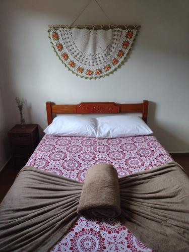 a bed with a blanket and a hat on it at Serra da Capela in São José da Barra