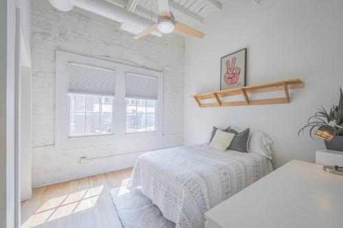 a white bedroom with a bed and a window at Darlin Downtown Dawghouse in Athens