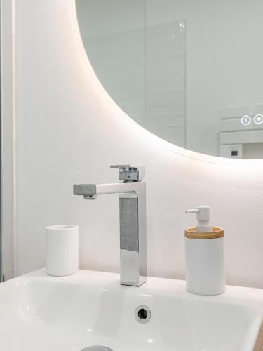 a bathroom sink with a faucet and a cup on it at Appartement face mer à Malo avec parking privé in Dunkerque