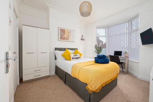 a bedroom with a bed with a yellow blanket on it at Spacious 4 bed - 4 en-suites - Parking - Discounts in Doncaster