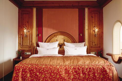 a bedroom with a large bed with a wooden headboard at Hotel Dollenberg in Bad Peterstal-Griesbach