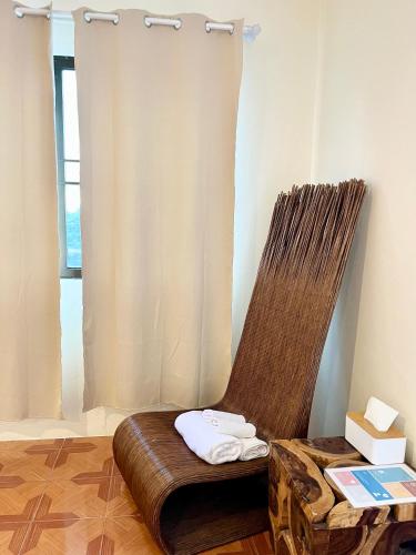 a brown chair sitting in a room with a window at inghome & guesthouse in Chiang Mai