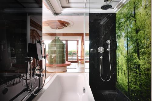 a bathroom with a bath tub with a shower at Hotel Dollenberg in Bad Peterstal-Griesbach