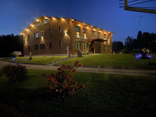 a large house with lights on the side of it at Ronnenburg apartamenti in Rauna