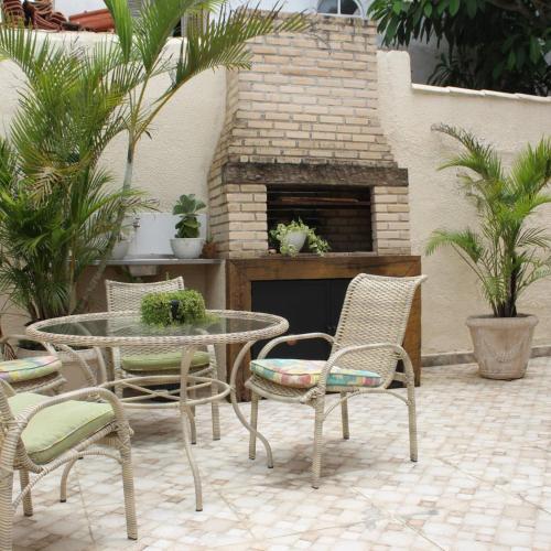 eine Terrasse mit einem Tisch, Stühlen und einem Kamin in der Unterkunft Buzios casa porto da barra in Búzios