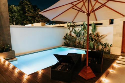 - Piscina con mesa y sombrilla en Slokayana Villas, en Uluwatu