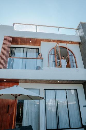 two people looking out of the window of a house at Slokayana Villas in Uluwatu