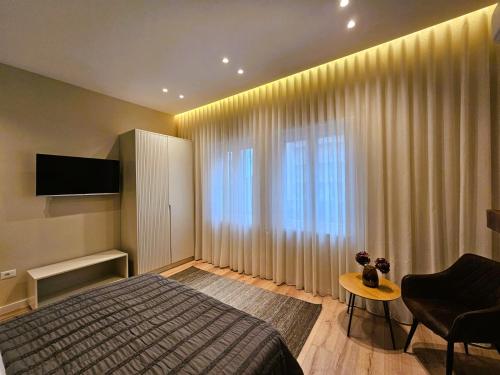 ein Schlafzimmer mit einem Bett und einem großen Fenster in der Unterkunft Rroji Urban Heritage in Shkodra