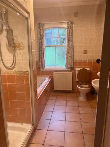 a bathroom with a shower and a toilet and a sink at The Gardener's House in Covington