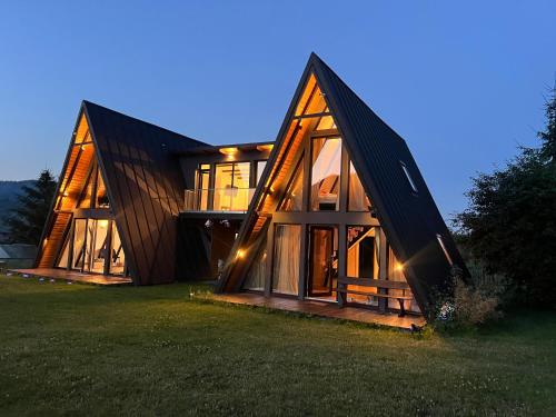 a large wooden house with a lot of windows at Zago Alpin in Câmpulung Moldovenesc