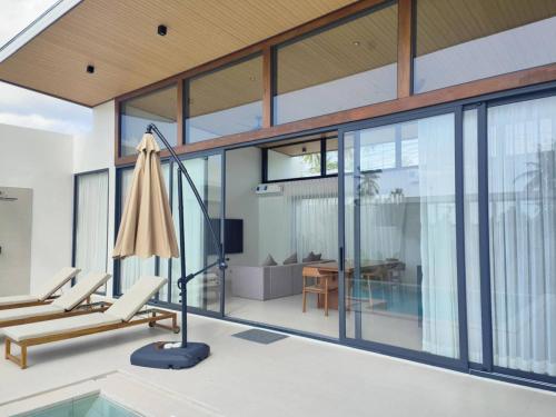 an open living room with a pool and a house at Samui Luxury villas -By Samui Rental Villas in Amphoe Koh Samui