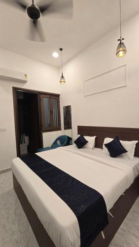 a bedroom with a large bed with blue pillows at JASMIN a luxury stay in Agra