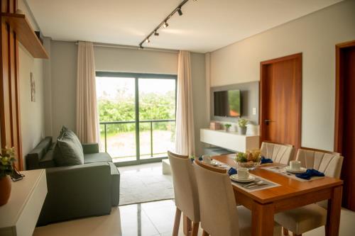 a living room with a table and a dining room at Apto c Churrasqueira e Piscina a 100m da Praia in São Bento