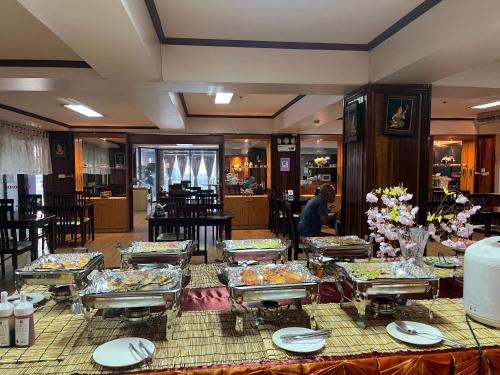 a buffet line with plates of food in a restaurant at Yamadaya Apartment in Phra Nakhon Si Ayutthaya