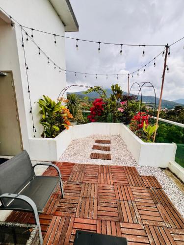 a patio with a bench and chairs on a deck at #MyLuxeGetaway,Quintet Cameron Highlands in Cameron Highlands