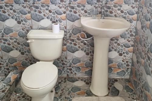a bathroom with a toilet and a sink at Charming 1-Bed Cottage in Codrington in Dulcina