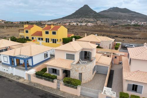 a group of houses with a mountain in the background at Casa Vista Azul With Pool in Porto Santo in Porto Santo