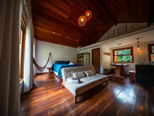a living room with a couch and a bed at Chalé Brandt Huss in Santa Teresa