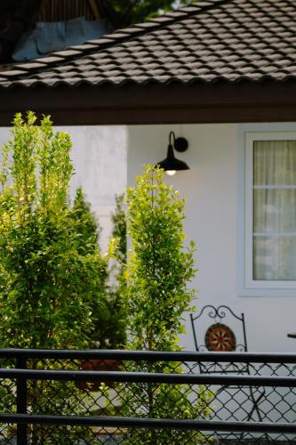 a white house with a black fence and trees at บ้านช่วงเวลาหนึ่ง - House of Moment in Chiang Rai