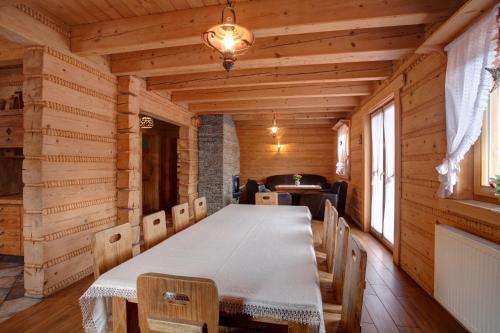 una sala da pranzo con tavolo in una baita di tronchi di Kotelnica Resort a Międzybrodzie Bialskie