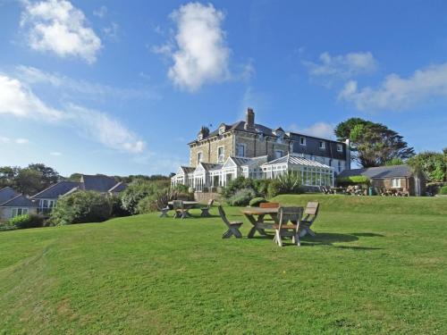 a large house with a picnic table in a field at Sure Hotel Collection by Best Western Porth Veor Manor Hotel in Newquay