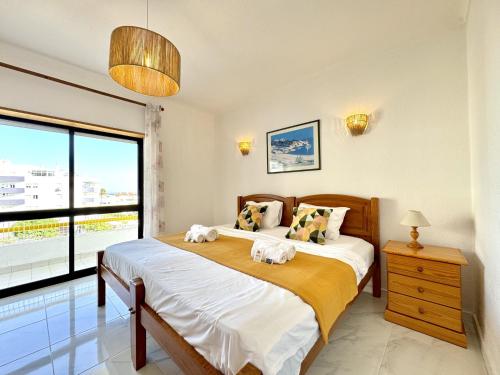 una camera da letto con un letto e una grande finestra di Albufeira Vintage Apartment 2 With Pool by Homing a Vale de Pedras