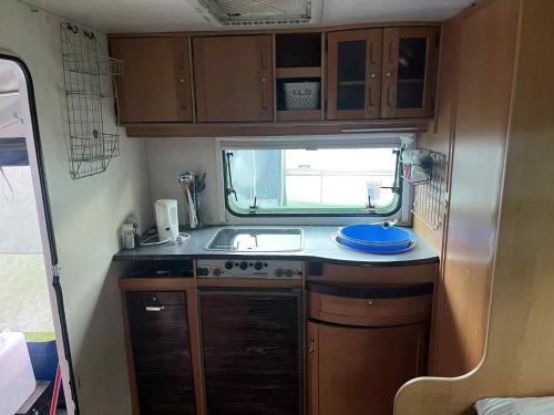 una pequeña cocina en una cabaña con fregadero en ArdennenHut on Wheels, en Durbuy