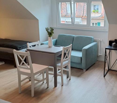 a living room with a couch and a table and chairs at Casa Maria Bern in Bern