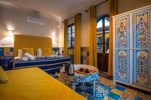 pokój hotelowy z dwoma łóżkami i stołem w obiekcie Dar Khmissa Riad & Spa w Marakeszu