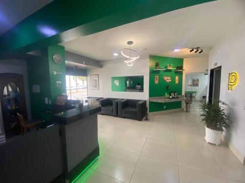 リメイラにあるLimeira Plaza Hotelの緑の壁のリビングルーム(ソファ付)