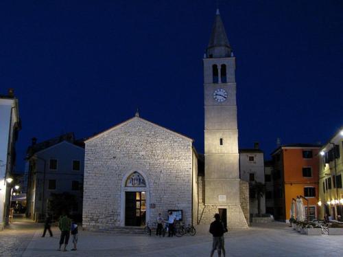 a church with a clock tower at night at Holiday Home Ulika in Fažana