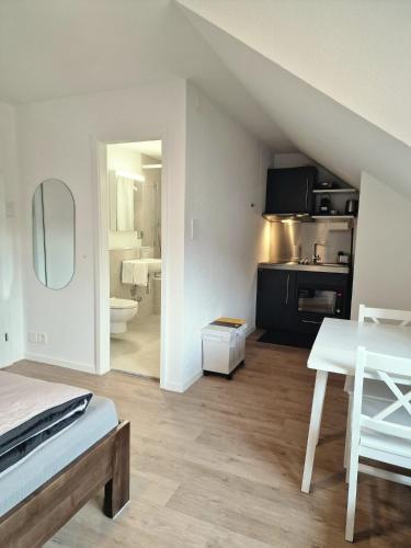 a living room with a table and a kitchen at Casa Maria Apartments Bern in Bern
