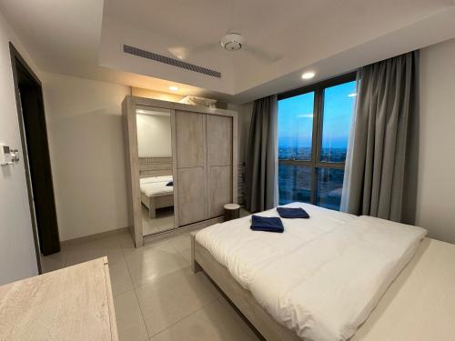 a bedroom with a large bed and a large window at Pinnacle Row Seaview Elegance in Muscat