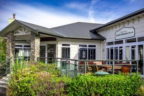 a white building with a sign on it at Ngati Ruanui Mountain Lodge in Stratford
