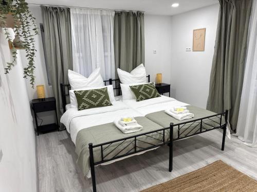 a bedroom with a large bed with green pillows at M B Homes Lauterstein 10 in Lützelalb