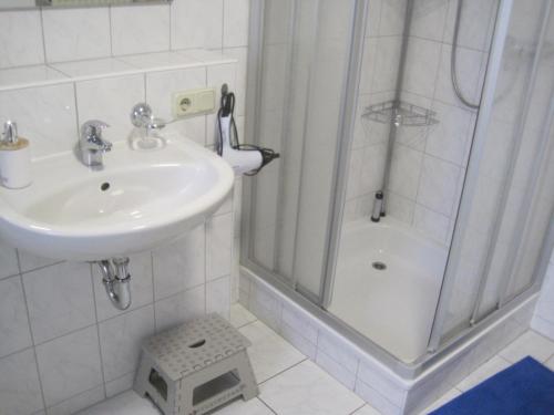 a white bathroom with a sink and a shower at Haus am Schaumberg in Tholey