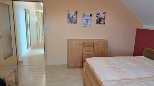 a bedroom with a bed and a dresser and a mirror at Haus am Schaumberg in Tholey