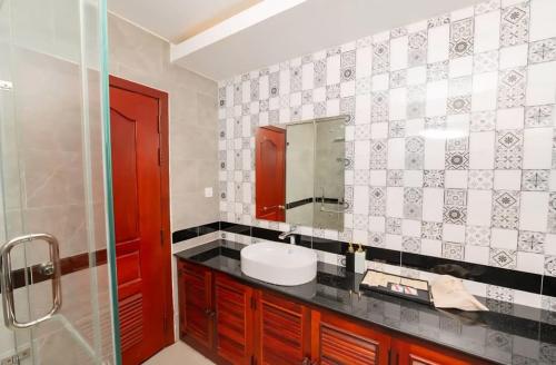 a bathroom with a sink and a mirror at Flex Suites in Phum Pobos